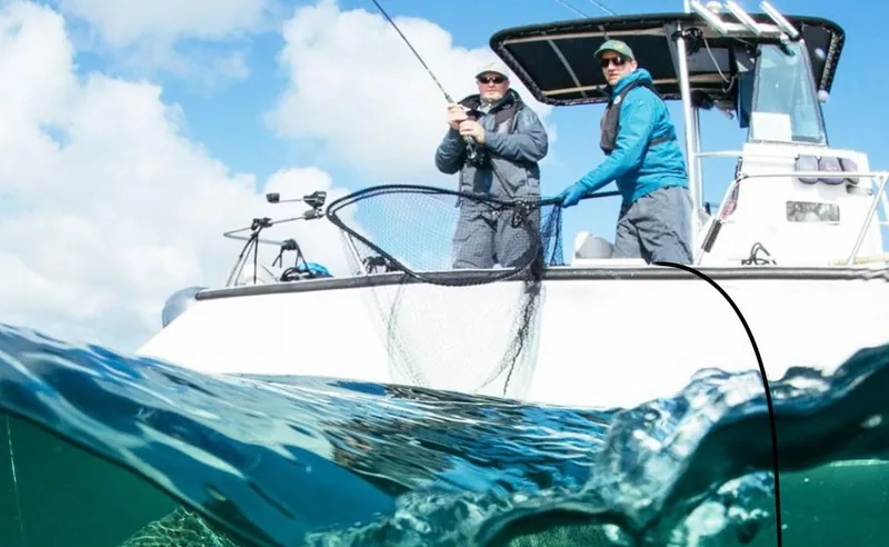 Two anglers working a line from a boat